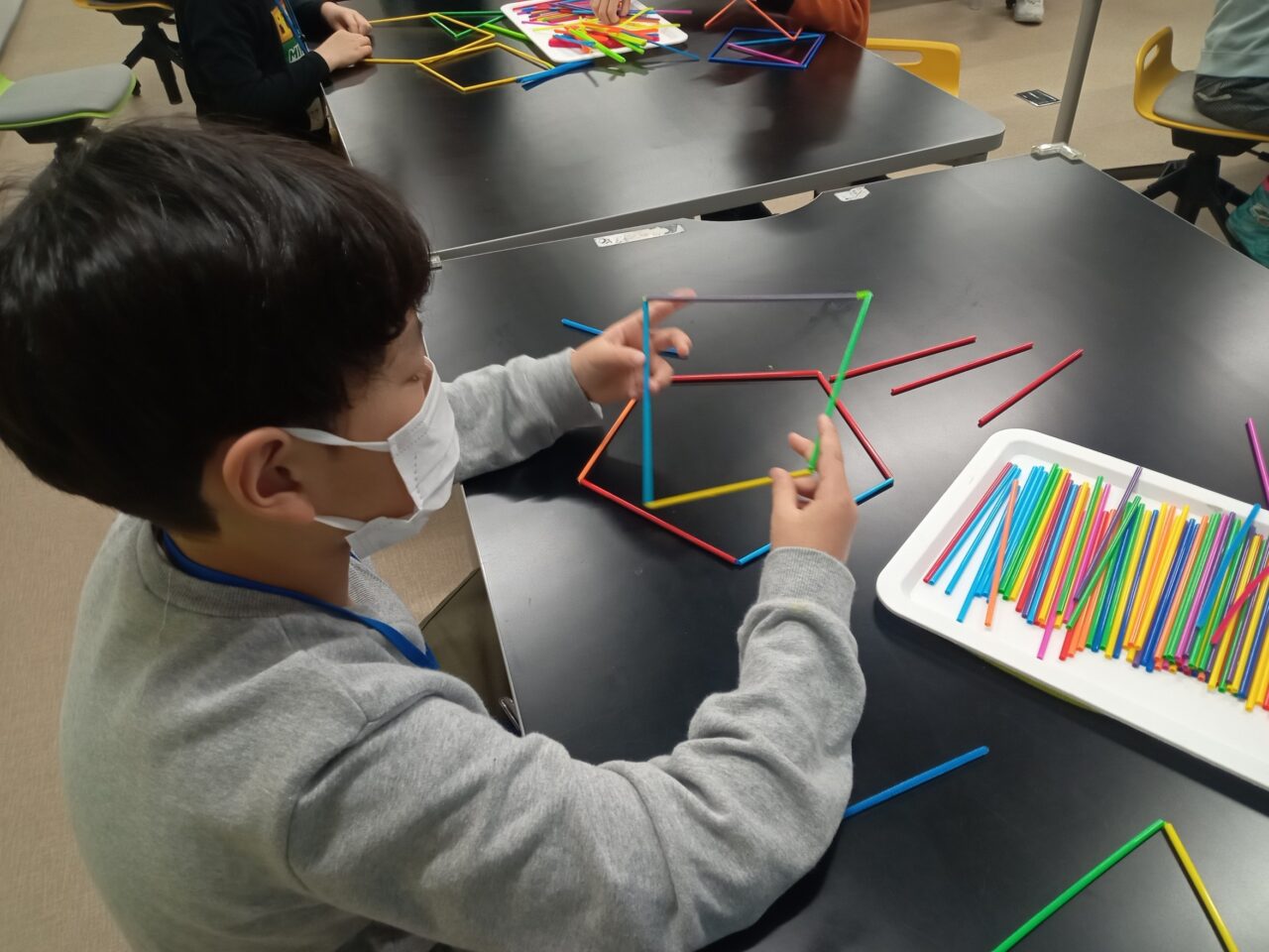 ストローやモールで図形をつくる子ども