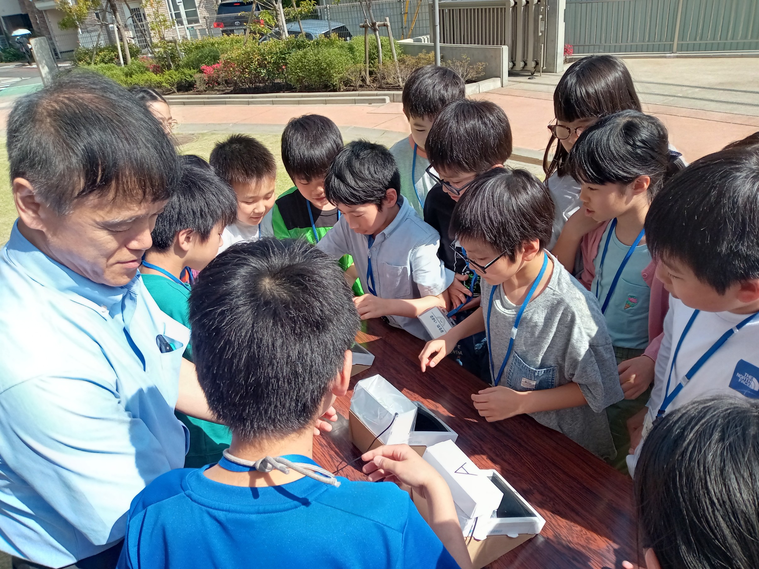 外で実験をする講師と子どもたち